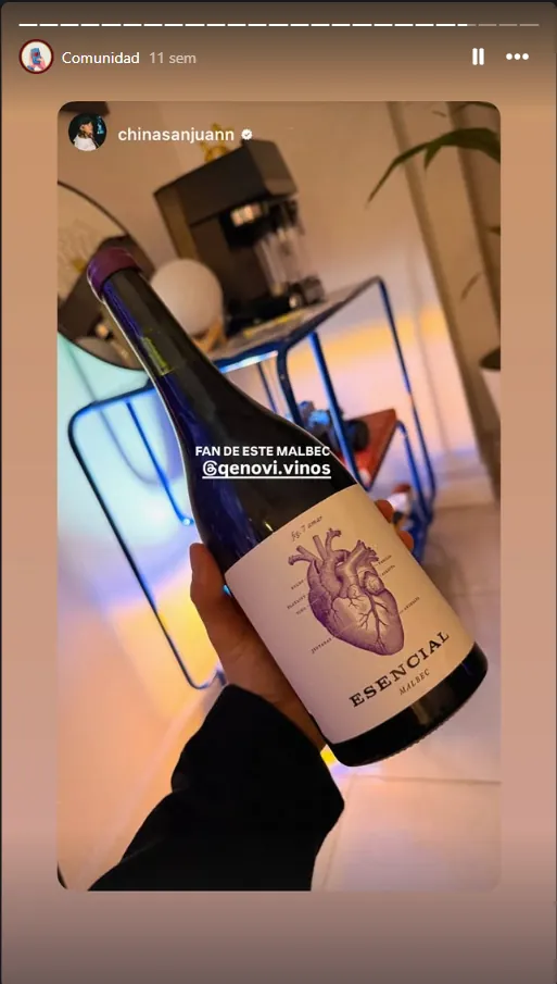 Clienta de Qenovi mostrando su vino Esencial Malbec